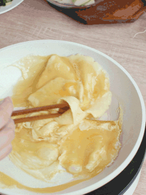 油6成熱時(shí)，下雞蛋液，邊緣凝固時(shí)翻拌成塊狀。