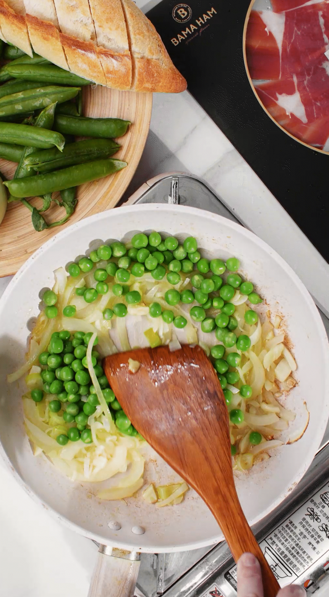 鍋中放入黃油融化，加入洋蔥絲、大蔥蔥白絲、蒜末翻炒變軟出香味。加入剛剛汆燙冰鎮(zhèn)后的豌豆，取出一點點待會擺盤裝飾用。加一點鹽 (和黑胡椒) 調(diào)味。