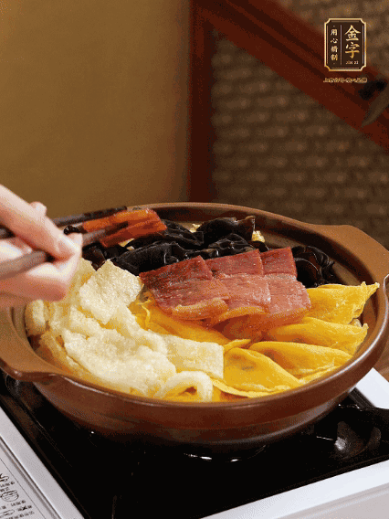 砂鍋底部鋪上娃娃菜，依次擺上肉皮、蛋餃、黑木耳、火腿